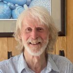 Headshot of Robin Loxton.He is smiling and has almost shoulder-length white hair and a beard.